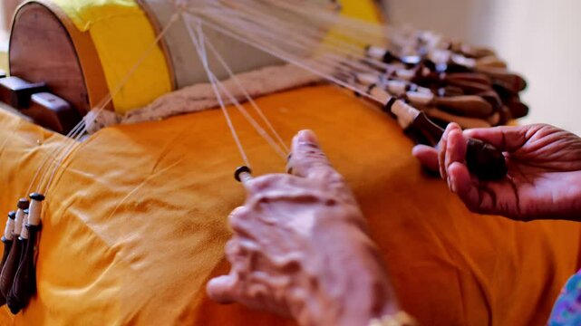 Close-up view of an elderly woman's hands skillfully weaving traditional bobbin lace.