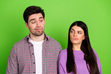 Young couple waiting and posing against green background showcasing unique emotions and expressions together