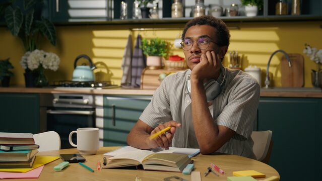Thinking pensive deep thoughts African American guy sad thoughtful business man male freelancer student think problem studying at kitchen difficult trouble solution home education brainstorm doubt