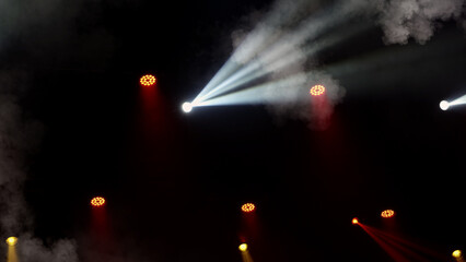 Stage lights background. Light beams and smoke from the stage spotlights on the stage at time of show. Laser show isolated on black background. Empty stage with light projector illumination backdrop.