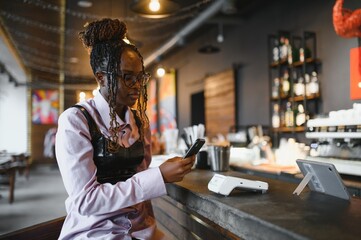 Customer paying with her mobile phone at a small cafe