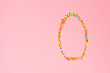 Colorful candy necklace shaped like an Easter egg on a pink background perfect for holiday celebrations and festivities