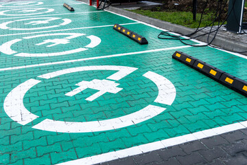 Several designated electric vehicle charging spots are highlighted in bright green at a parking...