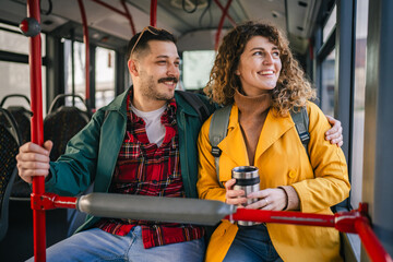 young caucasian couple talk and enjoy while riding a bus in the city