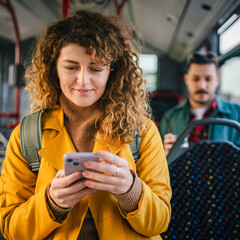 young adult woman enjoy while use mobile phone and riding a bus