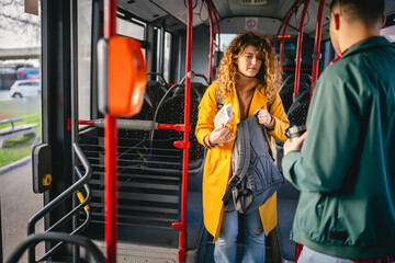 young caucasian couple riding a bus in the city ready to go out