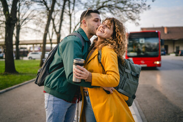 curly hair woman girlfriend hug with man on bus station