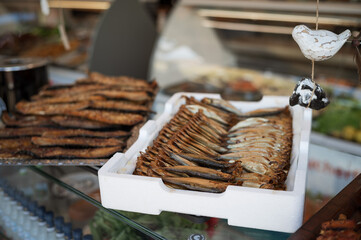 Dried sprats in a box on display in a shop window