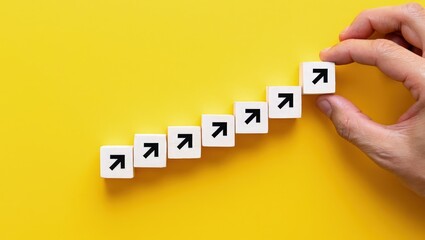 Hand making a row of arrows on a yellow background. Space for text. Paving the way, making plans. Next steps and vision. Course to go forward.