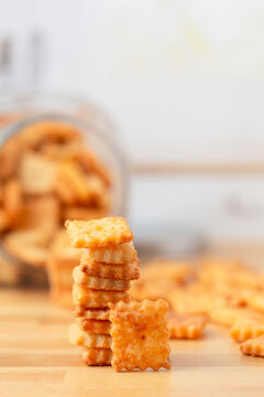 Homemade Cheese Crackers Stcked on Butcher Block Counter Top with Jar Full in Background