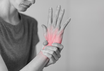 Woman suffering from pain in hands and fingers, arthritis inflammation. Red highlight
