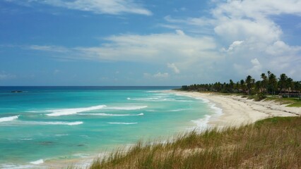 A scenic view of a beach and ocean from the top of a hill, suitable for use in travel or landscape photography