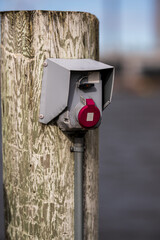 Close-up of industrial power socket on dock post.