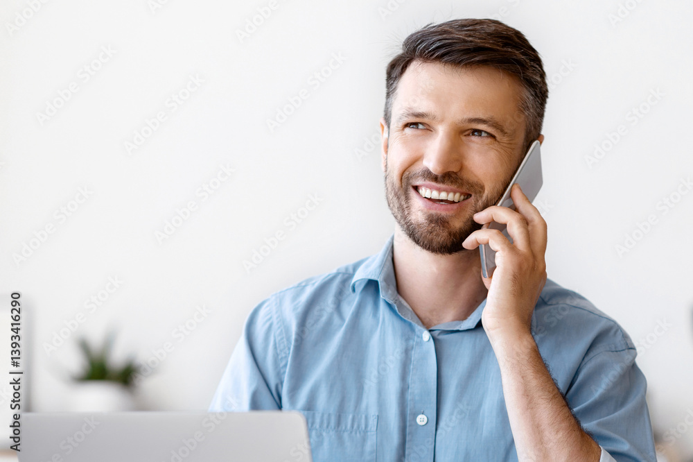 Aufkleber smiling businessman talking on cellphone while working at desk with laptop in office, enjoying mobil