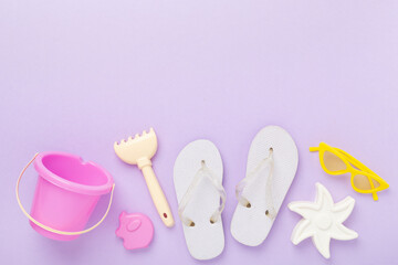 Children's flip flops and beach toys on color background,,top view