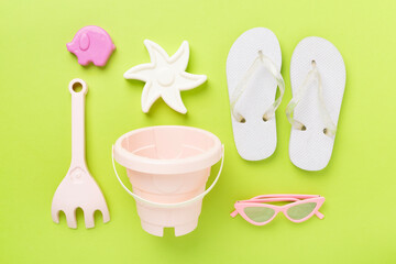 Children's flip flops and beach toys on color background,,top view