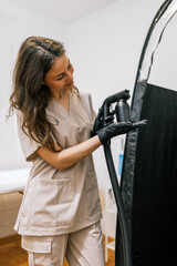 Beautician holds spray tan machine. Air brush in the salon.