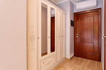 Beige wardrobe with mirrors at the entrance to the hotel room