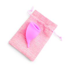 Menstrual cup and bag isolated on white background