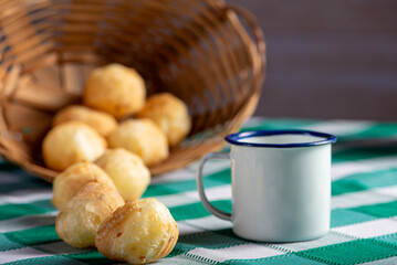 Brazilian cheese bread, delicious Brazilian cheese bread and accessories on a rustic table with a green and white checkered tablecloth, selective focus.