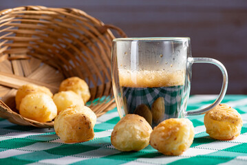 Brazilian cheese bread with coffee, delicious Brazilian cheese bread with a cup of coffee and accessories on a rustic table with a green and white checkered tablecloth, selective focus.