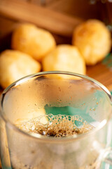 Brazilian cheese bread with coffee, delicious Brazilian cheese bread with a cup of coffee and accessories on a rustic table with a green and white checkered tablecloth, selective focus.