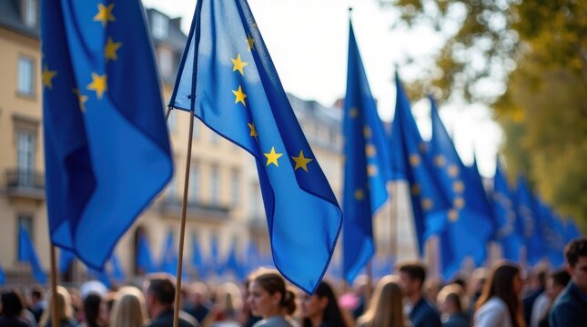 Crowd waving european union flags at outdoor gathering on a sunny day
