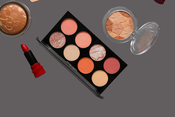 Beautiful palette of eyeshadows and different decorative cosmetics on grey background