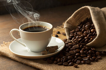 A steaming cup of dark, rich coffee, inviting warmth and comfort, nestled amongst a burlap sack overflowing with roasted beans, casting a warm, inviting glow.