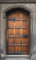 Ornate wooden door with gorgeous iron hinges and door knob.