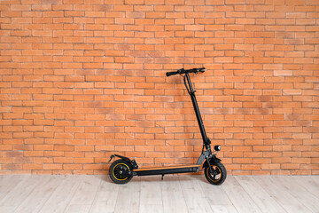 Modern electric kick scooter on brick wall