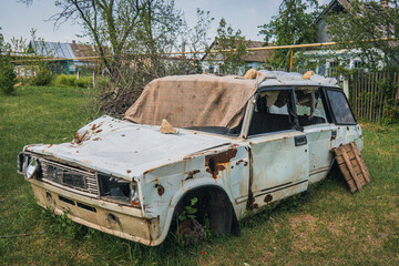 A car in the countryside, damaged by artillery fire. War in Ukraine