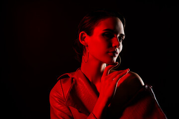 Photo of attractive sexy young woman touch soft skin neon red light dressed leather jacket on black color background