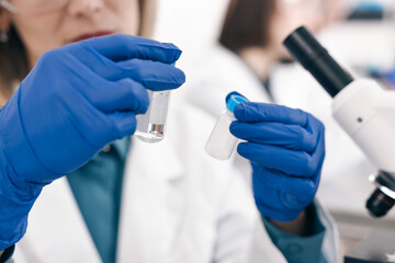 Scientist with vials working in laboratory, closeup