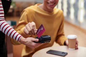 Man paying with credit card via terminal in cafe, closeup