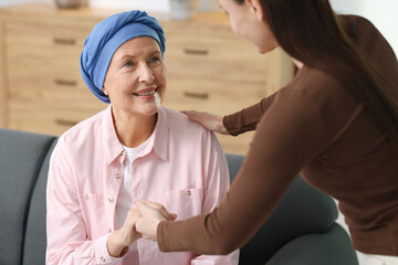 Caregiver helping woman with cancer at home