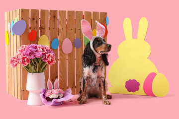 Cute cocker spaniel in bunny ears with Easter cake, paper eggs, rabbit, beautiful tulips and wooden...