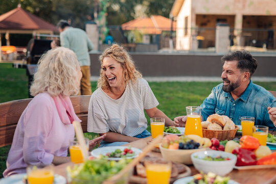 Family enjoying backyard barbecue with delicious food and laughter