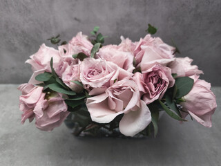 Delicate pink roses forming an elegant bridal bouquet on gray background wallpaper copy space