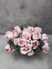 Delicate pink roses forming an elegant bridal bouquet on a gray background wallpaper copy space