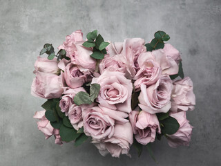 Delicate pink roses forming a bridal bouquet on a textured gray background wallpaper copy space
