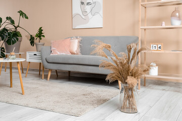 Stylish living room with comfortable sofa, coffee table and shelving unit