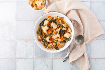 Top View of Tuscan Vegetable Soup in White Bowl with Bowl of Croutons
