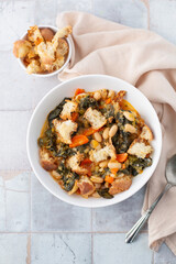 Top View of Tuscan Vegetable Soup in White Bowl with Bowl of Croutons