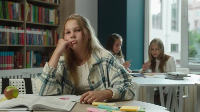 Boring school education sad frustrated bored kid Caucasian girl teenager pupil schoolgirl daughter child studying lesson in classroom difficult hard task reading book in library tired stressed student - Powered by Adobe