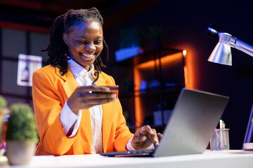 Overjoyed teenager doing internet shopping, carefully typing credit card information on laptop in...