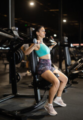 During training session in mini group of athletes, senior woman exercises on chest press machine....