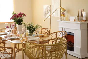 Beautiful table setting with flowers and fireplace for wedding celebration in room