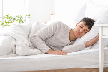 Young man sleeping in bedroom