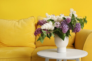 Lilac flowers in vase on coffee table in room